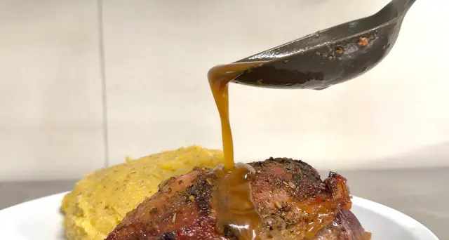 Sugo versato su carne con polenta